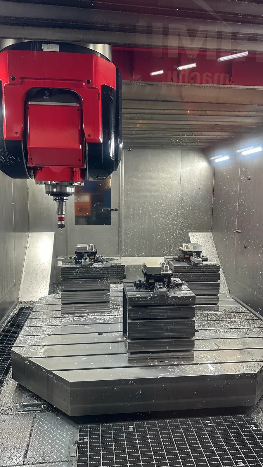 HERMLE 5-axis machining center cutting fixtured steel blocks, chips flying