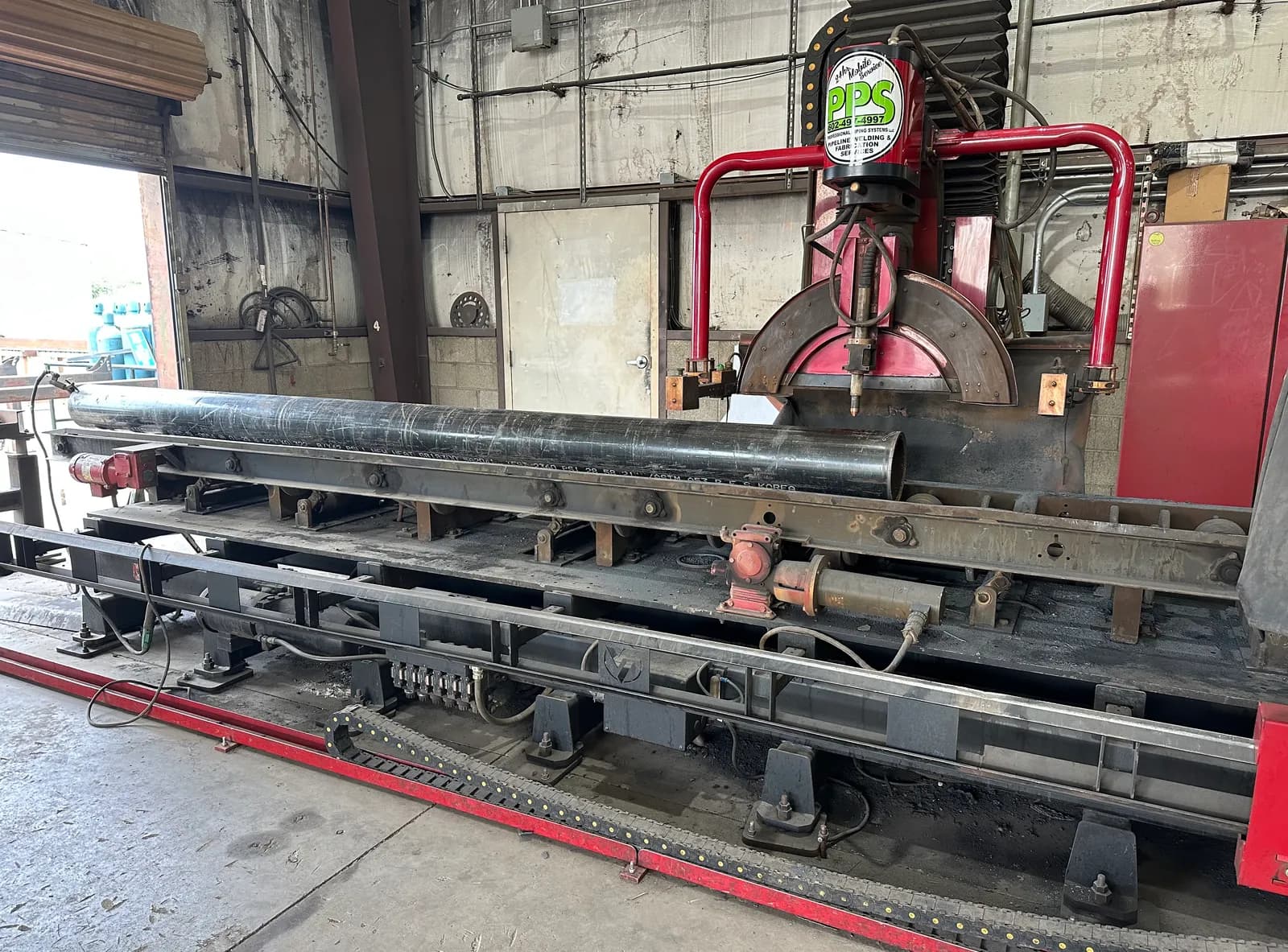 Horizontal band saw cutting a large steel shaft to length